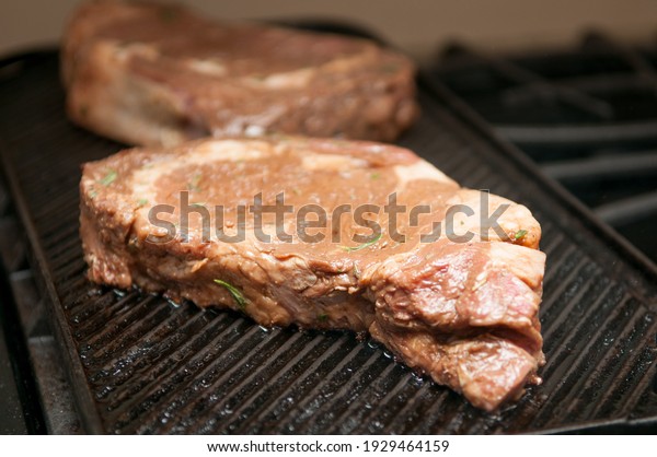 thick\
ribeye steak seared rare on a cast iron\
grill
