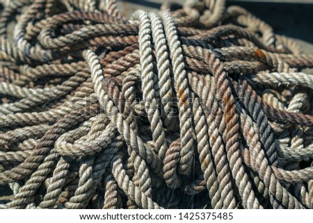 Thick rope in the web and rust. Anchor halyard. Old dirty rope