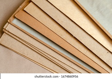 Thick Sheets Of Brown Cardboard. A Stack Of Rectangular Sheets Of Recycled Paper. Abstract Background. View From Above. Selective Focus. Close-up.