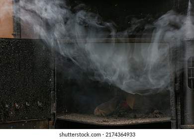 Thick Smoke Billows From A Coal Stove In Close-up. Wood Is Burning In The Oven.