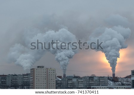 Thick smoke puffs from the pipes of the factory, the rays of the sun through the smoke