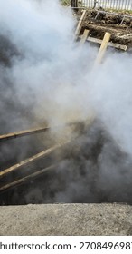 Thick steam rises from an open pit during repairs or emergency work on city utilities. Wooden supports, construction soil, and a smoking pit are visible. The scene illustrates the problems of aging he