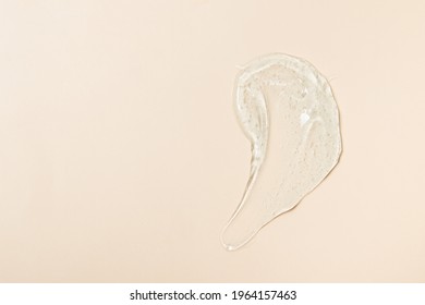 Thick transparent gel, cosmetics: soap texture, antiseptic, hyaluron smear on beige top view - Shutterstock ID 1964157463
