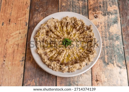 A thick version of baba ghanoush with bits of roasted eggplant skin, served as an accompaniment to grilled chicken skewers.