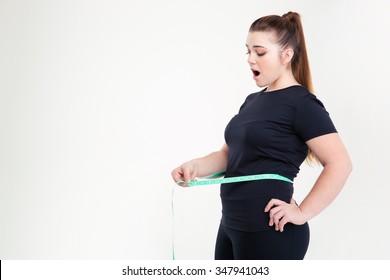 Thick Woman Measuring Her Waist Isolated On A White Background