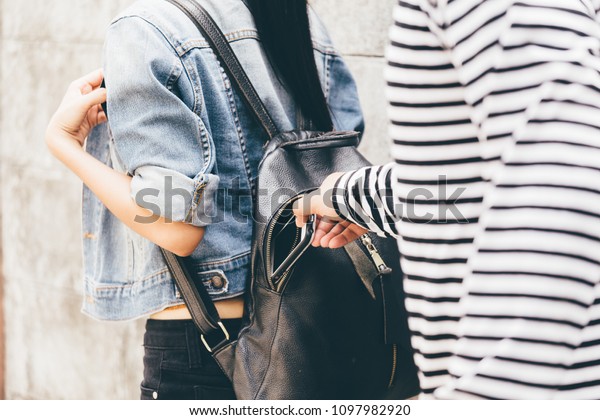 Thief Dangerous man or masked robber with knife\
attacking shoulder bag. Robber or thief holding knife burglarize to\
steal the money wallet in woman\'s bag, while standing near her car\
and don\'t careful