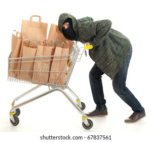 thief in dark clothes and balaclava with shopping cart full of papers bags