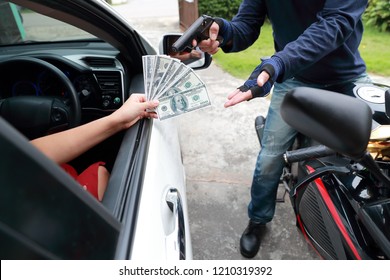 Thief With Gun On Motorcycle Stealing Money From Woman In The Car (theft Concept)