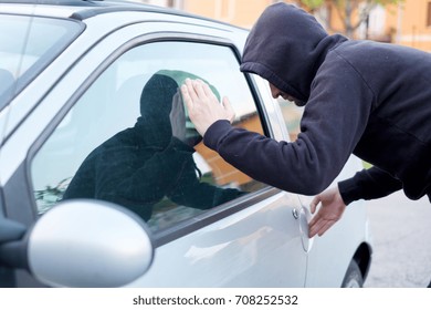 Thief Looking Inside A Car Window Ready To Steal Something