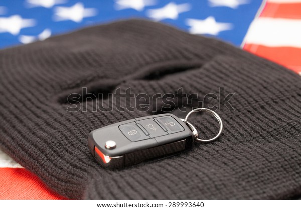 Thief mask with car keys\
over US flag