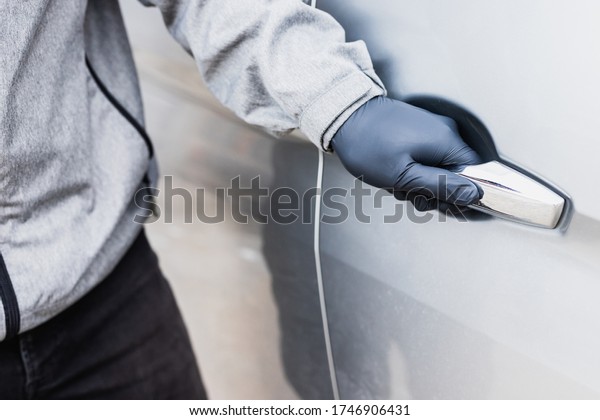 The thief pull up the door handle to\
Stealing a car. The vehicle insurance\
concept.