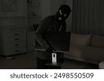 Thief stealing computer monitor at foreign house. Burglary