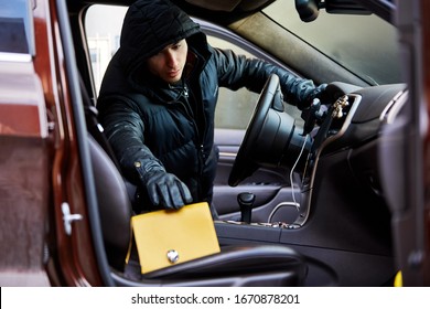 Thief Stealing A Handbag From An Open Car