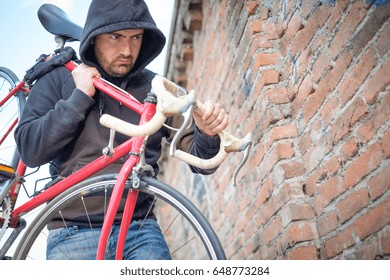 Thief Stealing A Parked Bike In The City Street