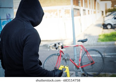 Thief Stealing A Parked Bike In The City Street