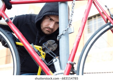 Thief Stealing A Parked Bike In The City Street