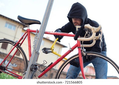 Thief Stealing A Parked Bike In The City Street