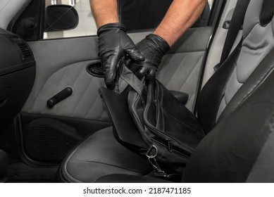 Thief Steals A Laptop Bag From The Passenger Seat From An Open Car Window. View From Inside The Automobile Interior. Concept Of Robbery.