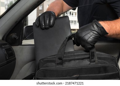 Thief Steals A Laptop Bag From The Passenger Seat From An Open Car Window. View From Inside The Automobile Interior. Concept Of Robbery.