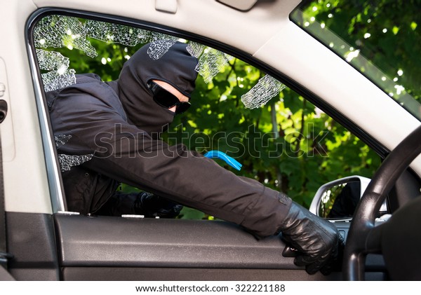 Thief\
successfully breaking a vehicle\'s\
window.