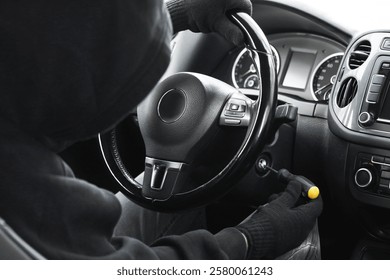 Thief trying to start ignition switch with screwdriver, closeup. Car hijacking