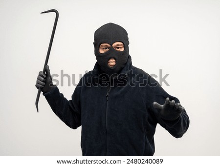 Thief in uniform black jacket various pose on isolated background. The Robber terrorism criminal escapes with balaclava and crowbar entering a house for stealing Housebreak