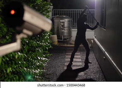 Thief use crowbar break into a house at window being caught by CCTV, surveillance camera - Shutterstock ID 1500443468