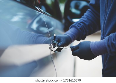 Thief Using A Tool To Break Into A Car.