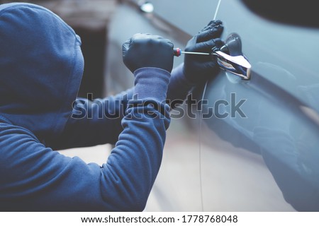 thief using a tool to break into a car. Foto stock © 