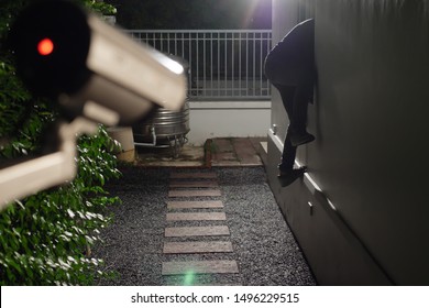 Thief wearing black suit with balaclava and glove being caught by CCTV, surveillance camera during sneak into a house at night - Shutterstock ID 1496229515