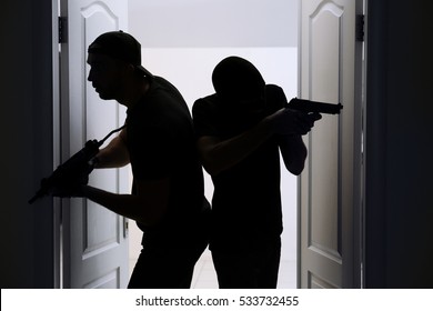 Thieves with gun entering the room - Shutterstock ID 533732455