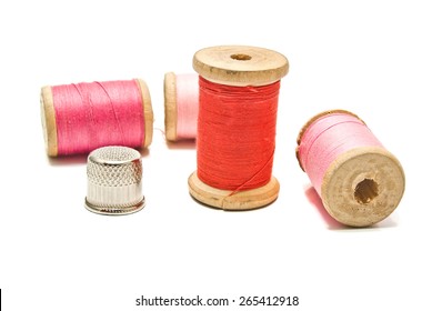 thimble and spools of thread on white background