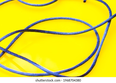 Thin Blue String On Yellow Background, Messy Thread Off The Spool Without Order, Jumble Of String.