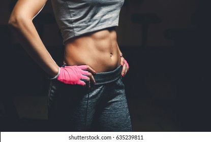 Thin, bodybuilder girl with a pumped up press on her stomach while training in the gym. Sports concept, fat burning and healthy lifestyle. - Powered by Shutterstock