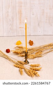 Thin church burning wax candle. Wheat ears and semiprecious stones, autumn ritual. Wicca, pagan beliefs, Craft, faith in God, religiosity. Copy space. - Shutterstock ID 2261584767