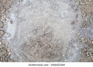 thin clear ice on a puddle. Ice technology. There are stones at the bottom.