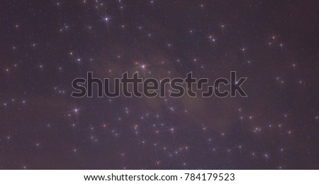 Thin cloud relfecting lights from the city bleow in front of a starry sky