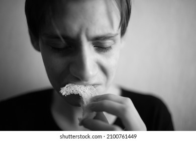 Thin And Emaciated Young Man Eating Bread