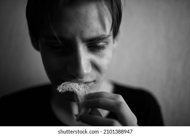 Thin And Emaciated Young Man Eating Bread