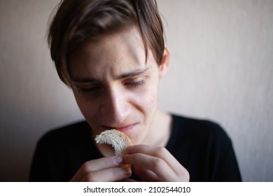 Thin And Emaciated Young Man Eating Bread