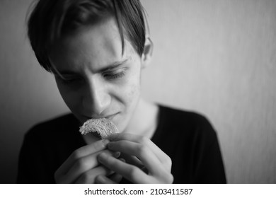 Thin And Emaciated Young Man Eating Bread