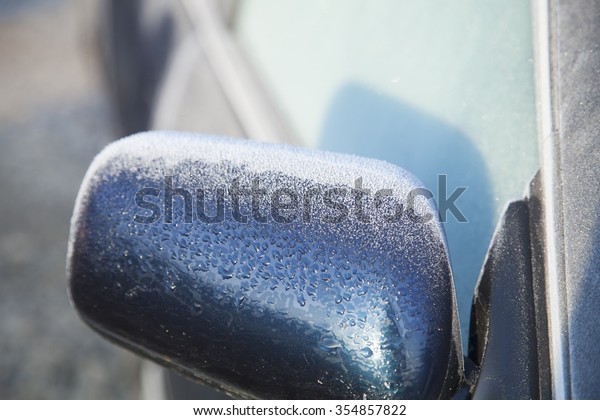 A thin film\
of icy frost covers this car - making the windshield too opaque to\
see through the window. Someone needs an ice scraper before they\
can start their morning commute.\

