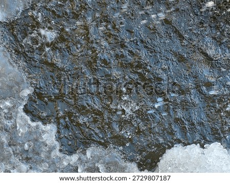 Thin layer of ice forming on the surface of calm water. Early winter frost, semi-transparent ice sheet, or seasonal weather change concept.