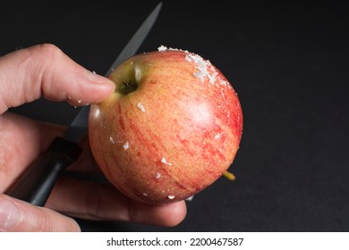 Thin layer white wax scraped with knife from the surface of a store-bought fresh apple. How to extend product shelf life? Waxing an apple. Black background. Food industry theme. - Shutterstock ID 2200467587