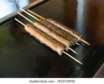 Thin And Long Beef Kebabs On Sticks Cooked On A Large Flat Gas Griddle At An Arabian Snack Joint.