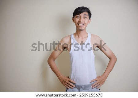 a thin man posing confidently wearing only an undershirt