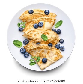 Thin pancakes or Crepes with fresh blueberries and mint leaves on a white background. Top view.