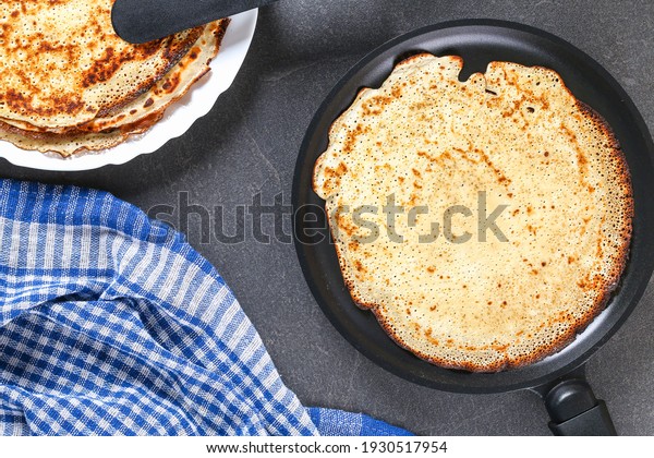 Thin pancakes from Russian cuisine. Russian blini,\
crepes on a gray background. Shrovetide holiday. Pancake week. Top\
view.
