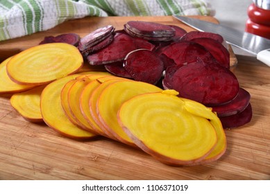 Thin Sliced Red And Gold Beets On A Cutting Board