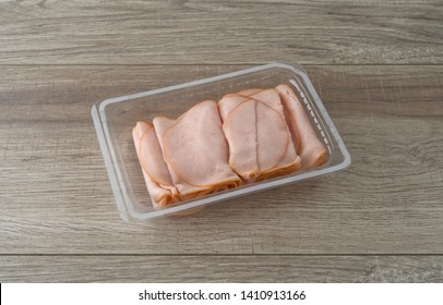 Thin Sliced Smoked Turkey Slices In A Plastic Tray On A Table Illuminated With Natural Light.